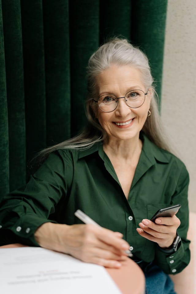 Femme En Veste Verte Tenant Un Smartphone